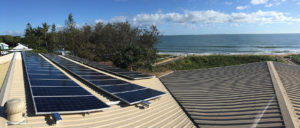 solar panels on a roof with the sea in the background